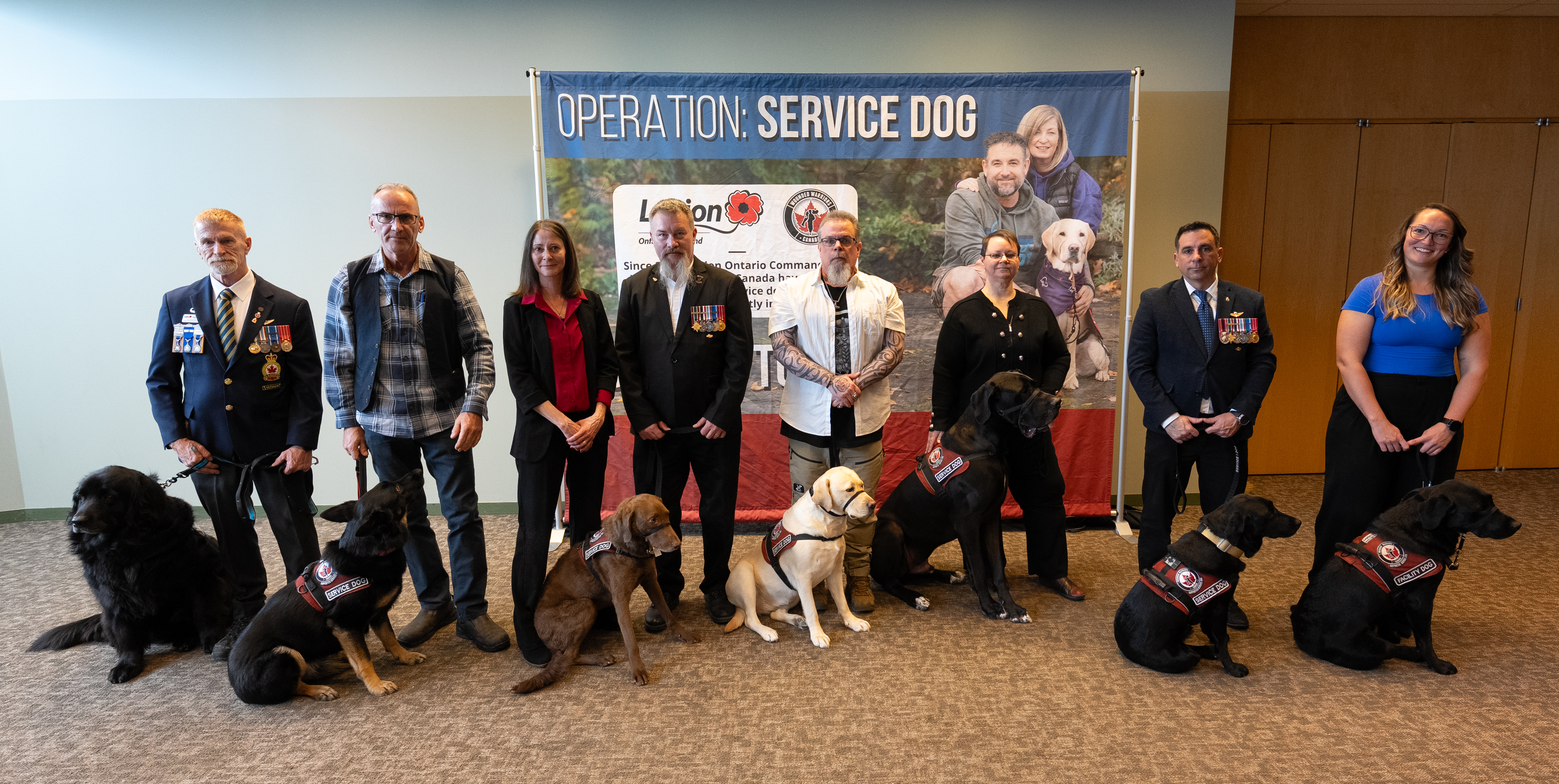Veterans standing with their service dogs 